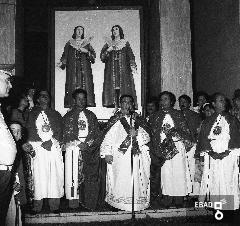 Autorit religiose tra cui padre Gabriele davanti al quadro che riproduce i S.S. Cosma e Damiano