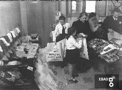 Persone impegnate a preparare pacchi regalo della befana fascista