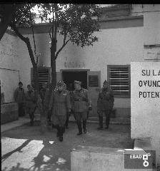 Militari ed autorit mentre attraversano un cortile.
[La foto  stata scattata nel 1940-1943 a SALERNO negli spazi di VIA BASTIONI dell'ex MONASTERO di SAN MICHELE ARCANGELO, di et longobarda e soppresso nel 1866; negli anni a cui risale la foto, una parte dell'ex Monastero era adibita a CASERMA della MILIZIA VOLONTARIA PER LA SICUREZZA NAZIONALE, indicata pi semplicemente con l'acronimo MVSN, ma anche identificata con l'espressione CAMICIE NERE.
In particolare la foto si riferisce alla visita in Caserma di un Console della MVSN. Su indicazione di Massimo La Rocca]
