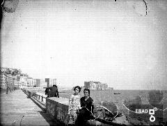 Donne in posa su un muretto del lungomare di Napoli