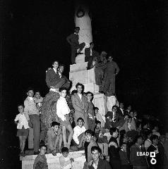 Persone sul monumento ai Caduti della I Guerra Mondiale durante uno spettacolo serale