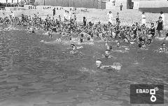 Bambini ed educatrici al mare durante il bagno.
La foto  stata scattata a Salerno nel 1937-1943 da una barca antistante lo stabilimento balneare Mussolini della colonia marina Mussolini. Stabilimento situato immediatamente ad ovest del molo 3 gennaio che si trovava alle spalle del fotografo. Oggi il luogo risulta profondamente cambiato e l'asfalto ha sostituito la spiaggia. Nota a cura di Massimo La Rocca]