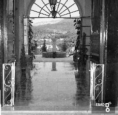 Portone d'accesso al monastero e scorcio del giardino oltre la vetrata