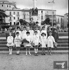 Scolaresca  con insegnante sulle scale del monumento ai caduti in piazza della Repubblica.
[Maestra Maria Sparano. Su indicazione di Mariano Pastore]