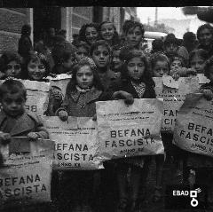 Bambini con regali della befana fascista