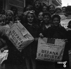 Bambini con regali della befana fascista