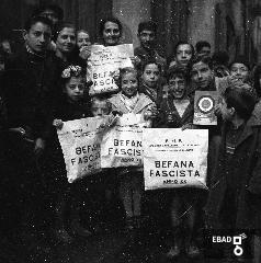 Bambini con regali della befana fascista